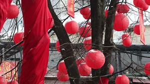 traditional red Chinese Lantern lamps covered with the snow on a wind outdoors