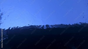 Sportsman is swimming in crawl style in swimming pool filmed from below in closeup slowmo. Male caucasian athlete is training before championship. Exercising in agility and speed. Healthy lifestyle