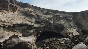 FPV cliff diving and water surfing. Ariel drone footage around a beach cliffside