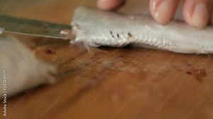 Chef hands prepare raw fish over cutting board. Closeup. Woman cooking raw frozen fish on kitchen