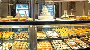 Pastry chef arranging display of delicious desserts in bakery shop window