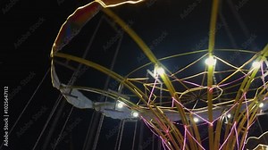 Fun swing, merry-go-round chain of empty chairs with no people riding it, swinging merry-go-round ride at night at carnival amusement park. Stock Video