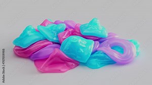 Colorful silicon geometric shapes fall and stack on each other. Close up of many vibrant semi transparent rubber objects jiggling.