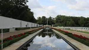 Cambridge England American war cemetery flag pool. Memorial commemorates American servicemen and women who died in World War II. Headstone crosses and religion symbols.