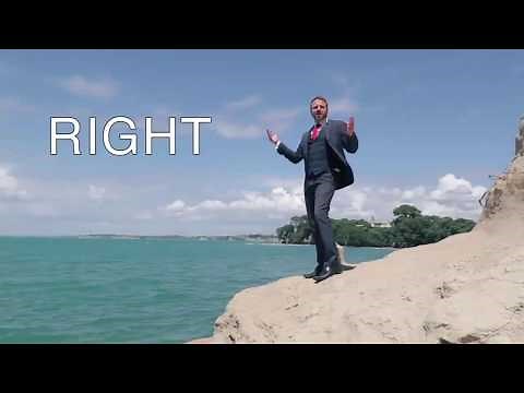 A man in a business suit jumps into the sea.