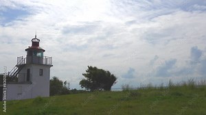 Hundested, Denmark A view of the Spodsbjerg Fyr lighthouse on the coastline and cloudscape in summer.