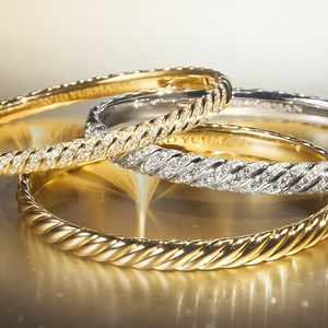 Discover precious metal designs, intricately carved with wavelike patterns that brilliantly catch the light. | David Yurman