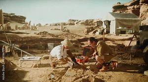 Archeological Digging Site: Two Great Archeologists Work on Excavation Site, Carefully Cleaning with Brushes and Tools Newly Discovered Ancient Civilization Cultural Artifacts, Fossil Remains
