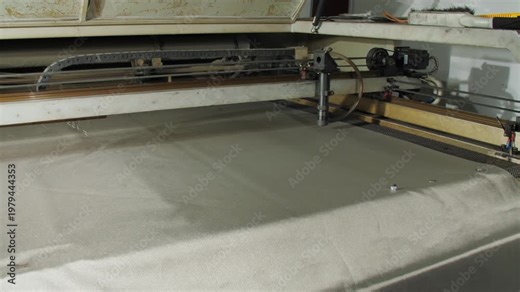 Radio-blocking fabric expertly handled in manufacturing workshop. Machine precisely shapes shielding material for electromagnetic protection