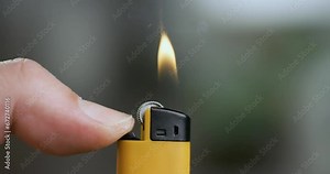Hand lights the lighter. Blazing lighter in hand on super slow motion.