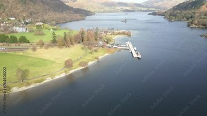 Drone panning from the left to the right side of the frame in front of a jetty by the lakeside of Ullswater Lake in Cumbria, England in United Kingdom.