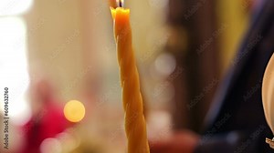 Church candle in the hands of woman and man at ceremony wedding in temple. Bride and groom at wedding ceremony in church holding candles in hands. Christianity or Catholicism, faith in God.Church rite
