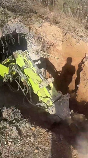 Confined Space Excavation: Mini Excavator with Hydraulic Drum Cutter Clearing Concrete Culvert