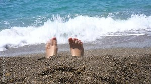 Close-up, the girl's feet buried in the sand, stirs the toes sticking out of the sand Stock Video