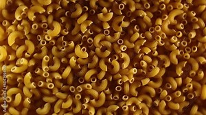 Uncooked Chifferi Rigati Pasta - Top View, Low Key Light. Fat and Unhealthy Food. Classic Dry Macaroni, Rotating Background. Italian Culture and Cuisine. Raw Golden Pasta Texture - Right Rotation
