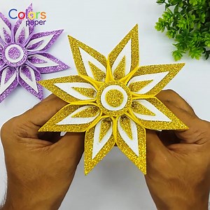 Elevate your holiday decor with a DIY Christmas star crafted from glitter foam paper. Create a sparkling handmade ornament by cutting out a star shape and adding a hanging string. This charming addition enhances your festive ambiance and adds a personal touch to your Christmas tree. 🌟🎄 | Colors Paper