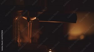 Spilling coffee in a small coffee machine. Steam from the drink.