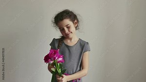 little girl holding rose flowers on white background. child sniffing a bouquet of flowers. holiday women's day birthday. little brunette girl with a bouquet of flowers lifestyle