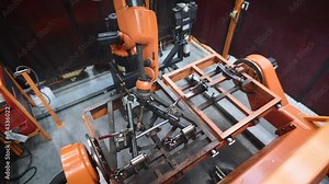 A robotized welding machine in a high-tech manufacturing plant. A precise robotic arm performs welding on a steel part. This cutting-edge equipment demonstrates the advanced technologies