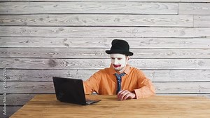 Office worker clown, clown concept at work. Businessman at the computer, work on a laptop.