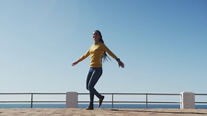 African american woman dancing on promenade by the sea | Free Stock Video Footage