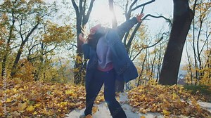 Attractive hiphop dancing contemporary dance into music enjoying rhythm performing in cinematic autumn park. Fall background.