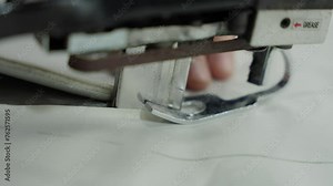 Close-up of Sewing Machine Foot on Fabric. Sewing machine foot and needle in action on cloth. Concept Tailoring Process