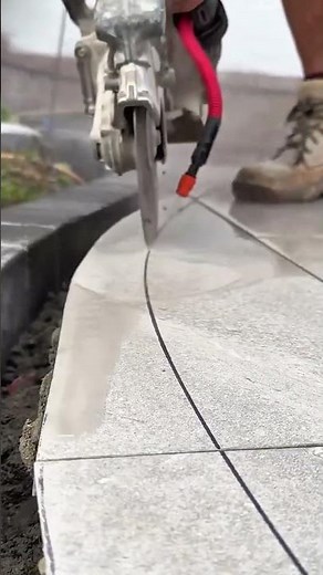 Concrete yields beneath spinning blade—dust rises, line etched