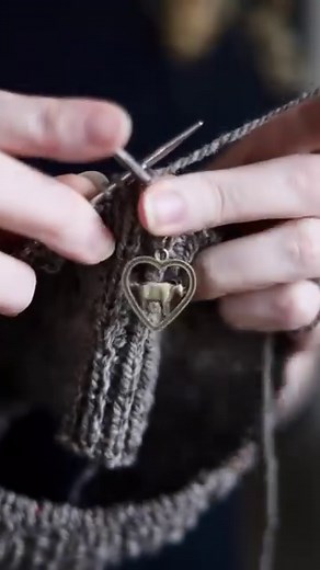 This cute little goat in a heart charm on my knitting project actually has a purpose. It is called a stitch marker and sits on my needles between two stitches. This one tells me when I am starting a new round. I simply slip it from one needle to the other and continue knitting so it travels up the project as I work. This is a very simple pattern, so I only need one, but some patterns use many stitch markers in different places to help keep track of where you are in the project.💗 | Cedar Hill Fi