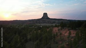 Devil's Tower National Monument at Sunset. Drone video flying low over trees with Devil's Tower in the distance.