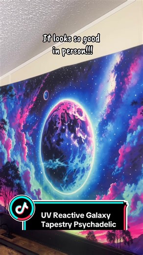 This UV-Reactive Planet Tapestry turns your wall into a portal. A neon cosmic landscape with glowing planets, surreal skies, and reflective water, this piece comes alive under blacklight, radiating vibrant purples, blues, and electric pinks that feel straight out of a lucid dream. Printed on peach-light beige fabric, the colors pop without looking harsh in daylight; and absolutely ignite when UV light hits. The neon gradient design creates depth and movement, making small rooms feel bigger, dark