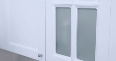 clip-4001957301-woman-taking-toilet-paper-roll-cabinet-restroom