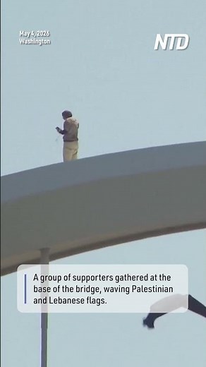 Protester Atop Washington Bridge Waves to Supporters Gathered Below