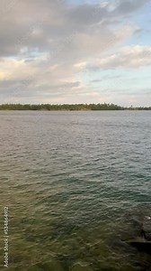 Panning view looking out over the vast expanse and pure waters of Lake Superior from the coast of Rock Harbor on the Northern island of Isle Royale. Lichen covered rocks are in the forefront of view.