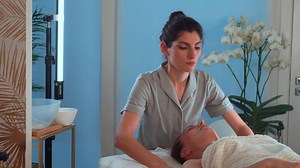 Woman receiving facial massage at cosmetology clinic