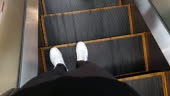 4K Walking Point of view . Feet moving down and getting off escalator