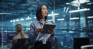 Beautiful Asian Female Cybersecurity Expert Works on Her Tablet Computer in a Modern Facility, Running Diagnostic Tests to Identify Network Vulnerabilities in a Data Center with Server Racks