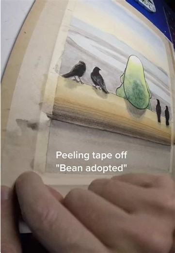 Peeling tape off “Bean Adopted” Once a Bean illustration has full dried and cured, I’m able to peel the tape off that’s held it to the birch boards I love to draw and paint on. After this the new piece will get scanned on my flat bed scanner, after which I can add this as a page to a future Bean book, and make a shirt or sticker from it. The possibility are endless with a bit of creativity. Check back soon for another new Bean illustration. Or make a request of your own and if it resonates, I mi