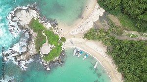bird's eye view of two beaches with boats, palm trees, blue sea water