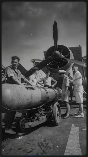 RN sailors prepare to attach a torpedo to a Fairey Swordfish on HMS Illustrious while serving with the Eastern Fleet in the Indian Ocean, standing together and quietly discussing the task. October 20, 1942 #ww2 #aviation #aircraft #military | World War II Aircraft