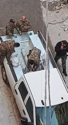 Lebanese soldiers carefully remove an unexploded rocket.
