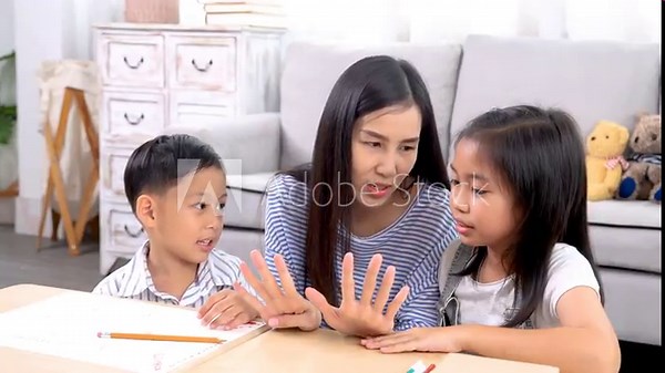 Multitasking mother teaching homework counting number reviewing basic math for cute sibling elementary school children, Asian mom woman take care kids enjoy playtime activity sitting on sofa together