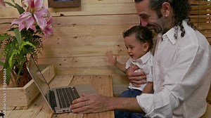 father teaching his son on laptop baby learning in computer with his father
