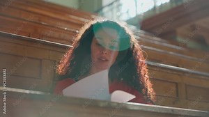 Hispanic woman girl student turning pages in textbook start learning in class lecture female study at table writing studying write learn course in college university sunny sunbeam auditorium education