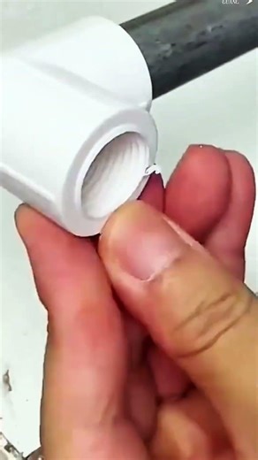 Drill carves plastic cylinder clean, white shavings scatter swiftly