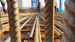 Builder walking on steel reinforcement. RC concrete rebar.