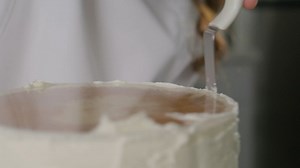 Covering a cake with icing in a close shot - Free Stock Video