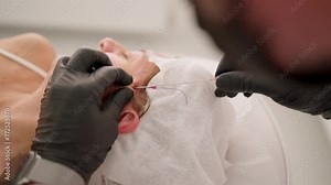 Performing thread face lifting in medical center. Cosmetologist performs thread lifting procedure to rejuvenate face. Concept Rejuvenation, cosmetology, innovation