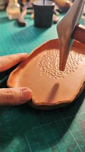 “Metal tool dots clay surface—hidden artistry emerges through rhythmic precision…”