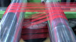 Spinning spools in the textile factory unit. close-up spools of yarn thread industrial warping machine in textile factory plant machine spools clews fiber on rack Textiles equipment in work.4K video.